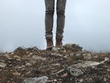 Hiker wearing durable boots stepping lightly over rocky terrain at dawn.