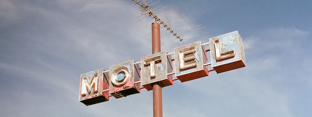 brown metal Motel road sign at daytime