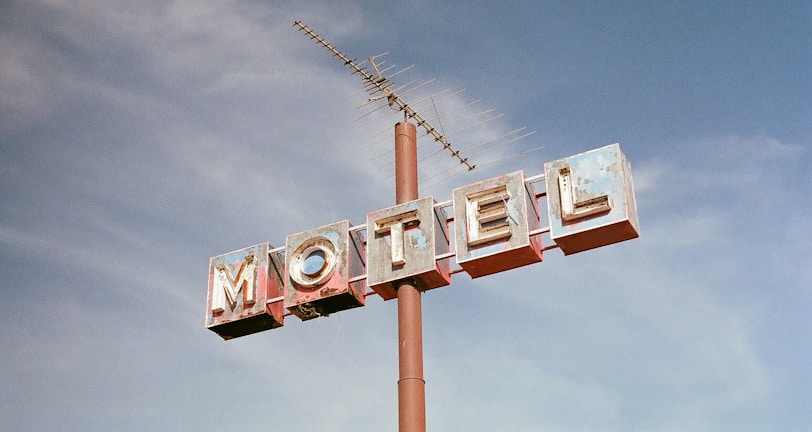 brown metal Motel road sign at daytime