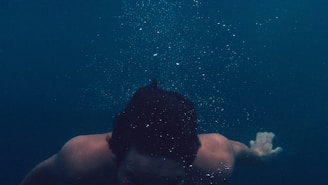man submerged on body of water