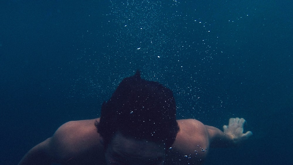 man submerged on body of water