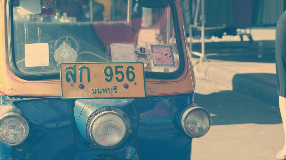 Rickshaw automático azul y amarillo en la carretera durante el día