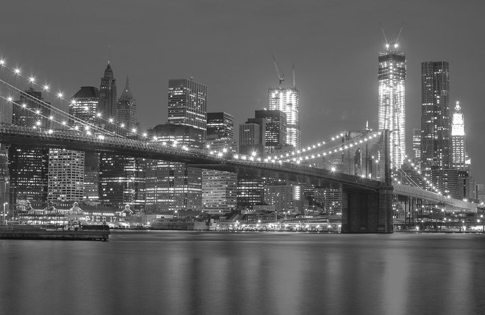 grayscale photo of lighted Brooklyn Bridge