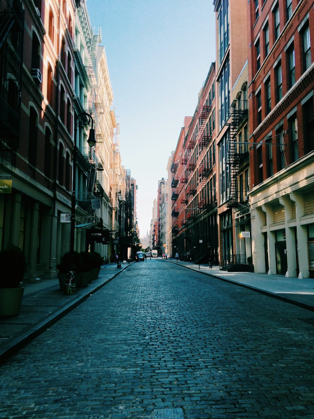 photo of road between brown buildings