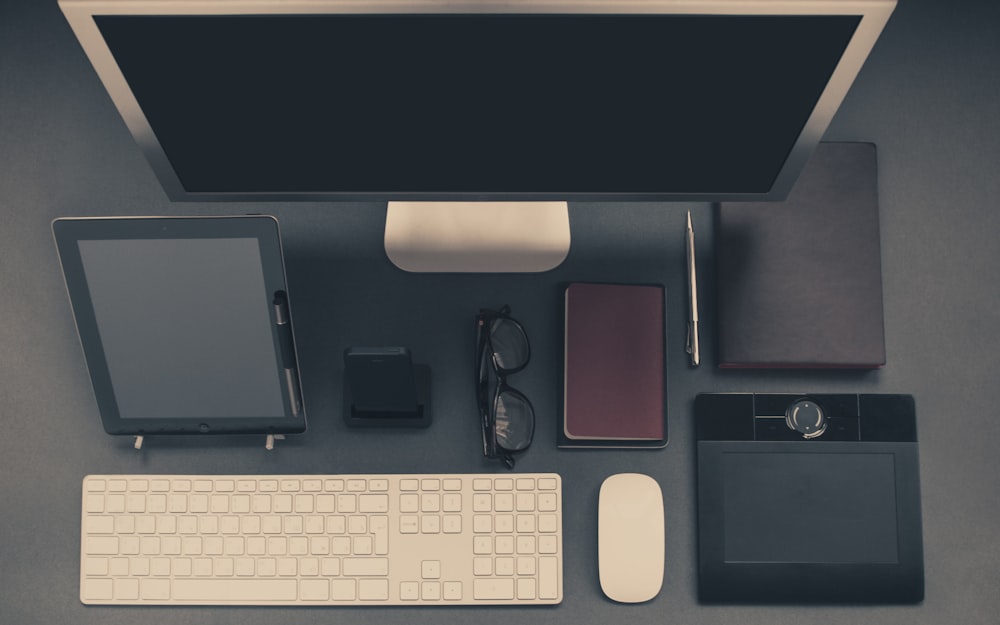 gray computer set with tablet and eyeglasses