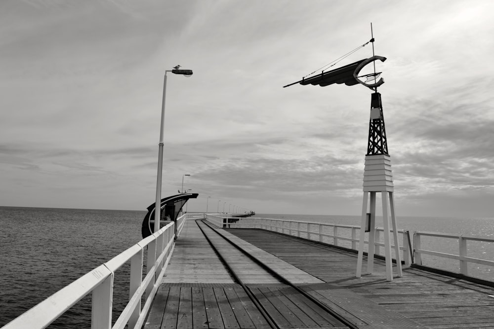 wooden wind vane on bridge near the body of water