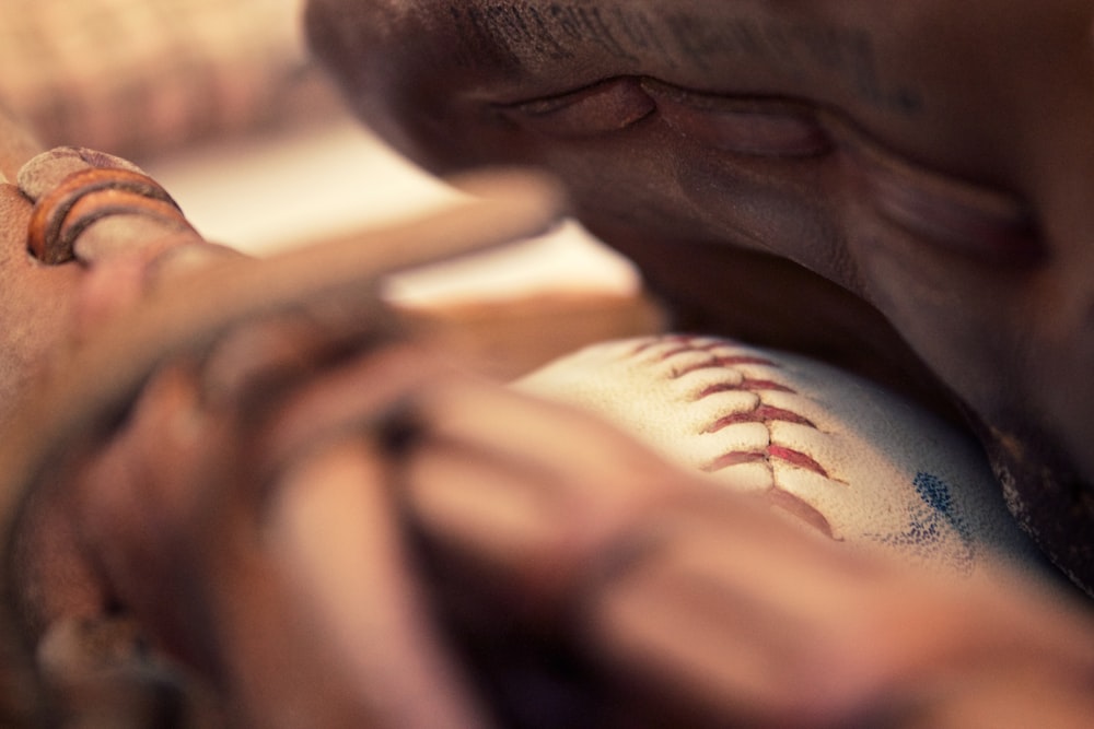 Un primo piano di una persona che tiene una mazza da baseball