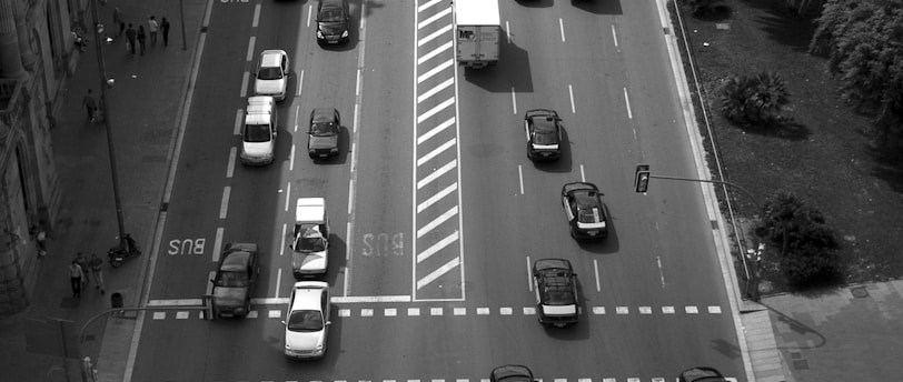 birds eye view of vehicles on road between buildings