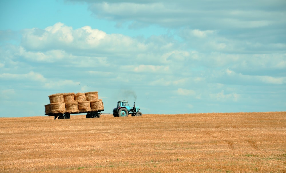 heno marrón en el tractor bajo el cielo blanco y azul durante el día