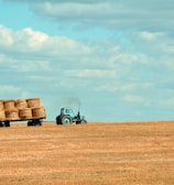 brown hay on tractor under white and blue sky during daytime