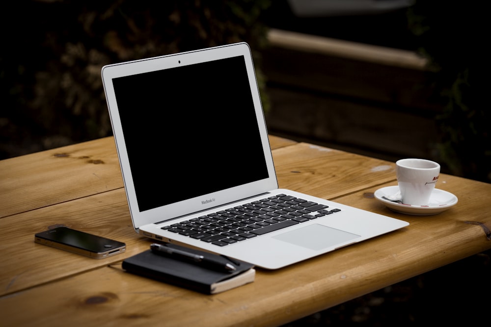 MacBook Air cerca de la taza sobre la mesa