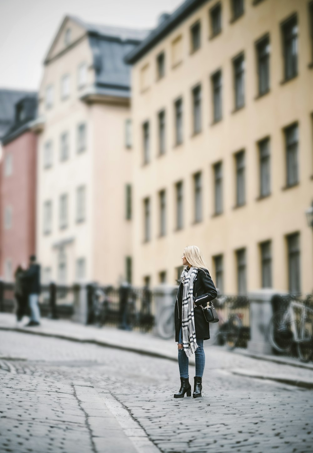 woman standing on pathway near building during daytime