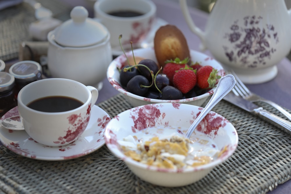 white ceramic plate with stainless steel fork beside red and white ceramic mug on table