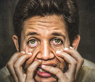 A close-up of a tenor's expressive face during a dramatic moment in an opera.