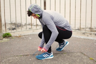 A dynamic urban athlete tying shoelaces before a run at dawn.