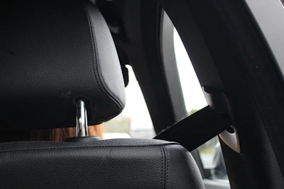 Close-up of a car seatbelt with a small baby doll symbol attached, symbolizing fetal protection.