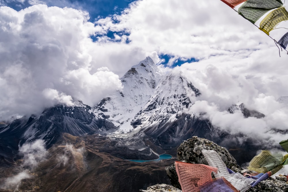 montagne rocheuse enneigée sous ciel nuageux blanc pendant la journée