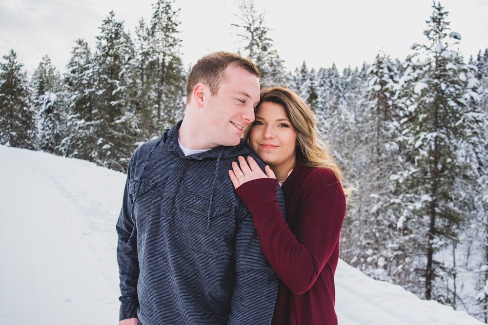 man and woman hugging on top of snow mountain