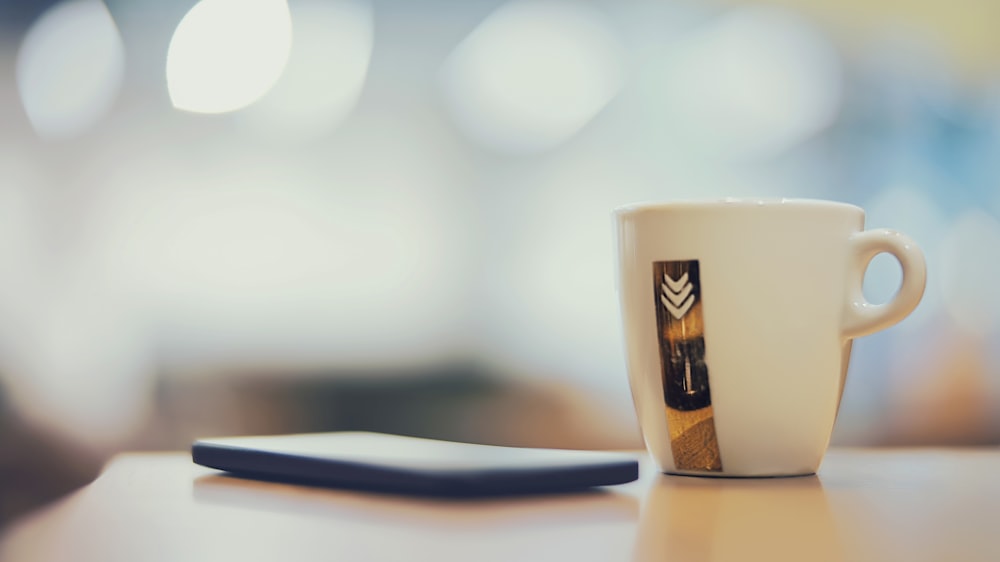 selective focus photography of white ceramic mug on brown surface