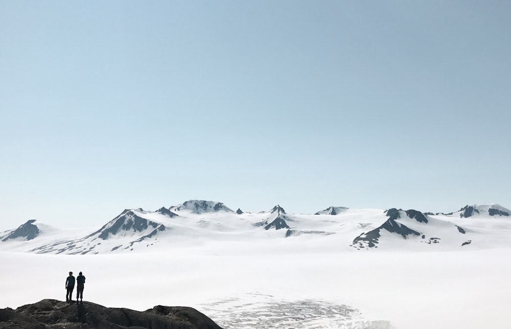 two person standing on hill during daytime