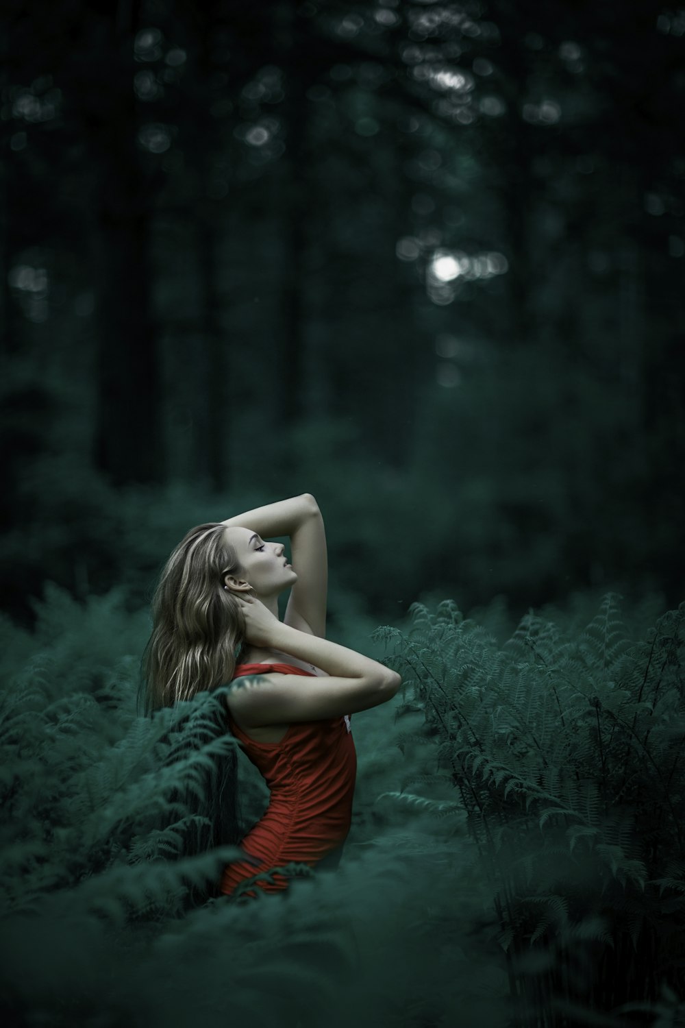 Frau steht mitten im Wald