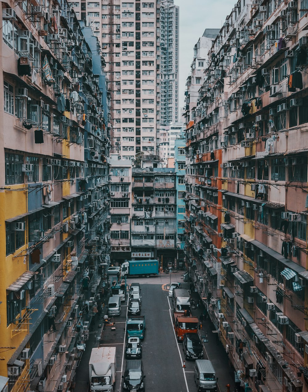 aerial photography of vehicles on road between concrete mid-rise buildings during daytime