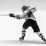 man wearing green and white ice hockey jersey while playing