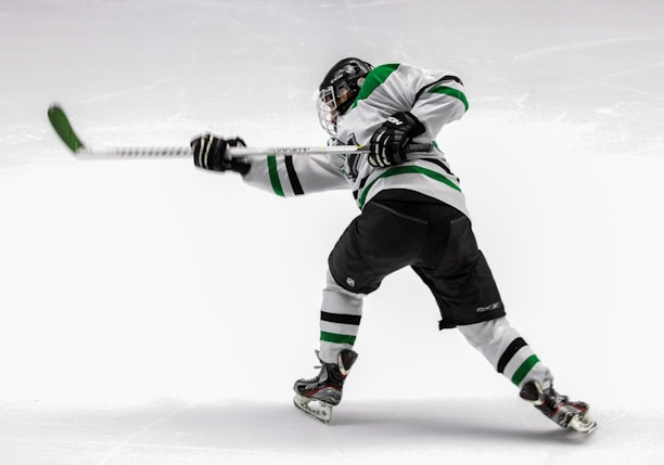 man wearing green and white ice hockey jersey while playing