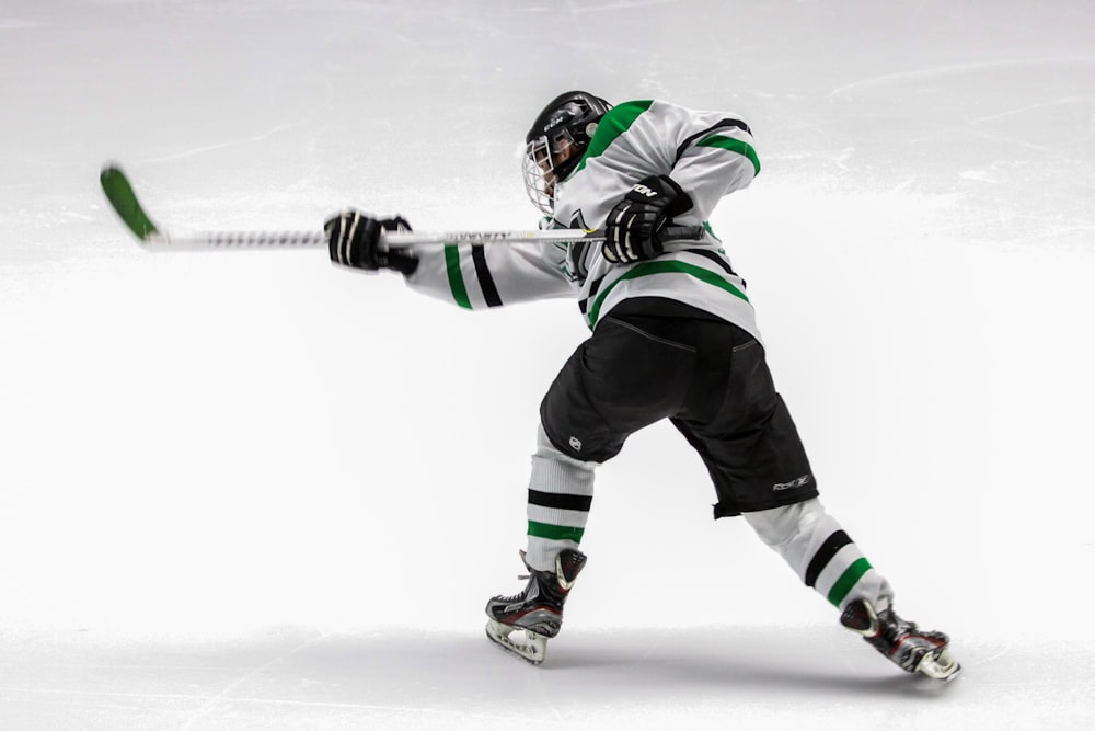 Uomo che indossa una maglia da hockey su ghiaccio verde e bianca mentre gioca