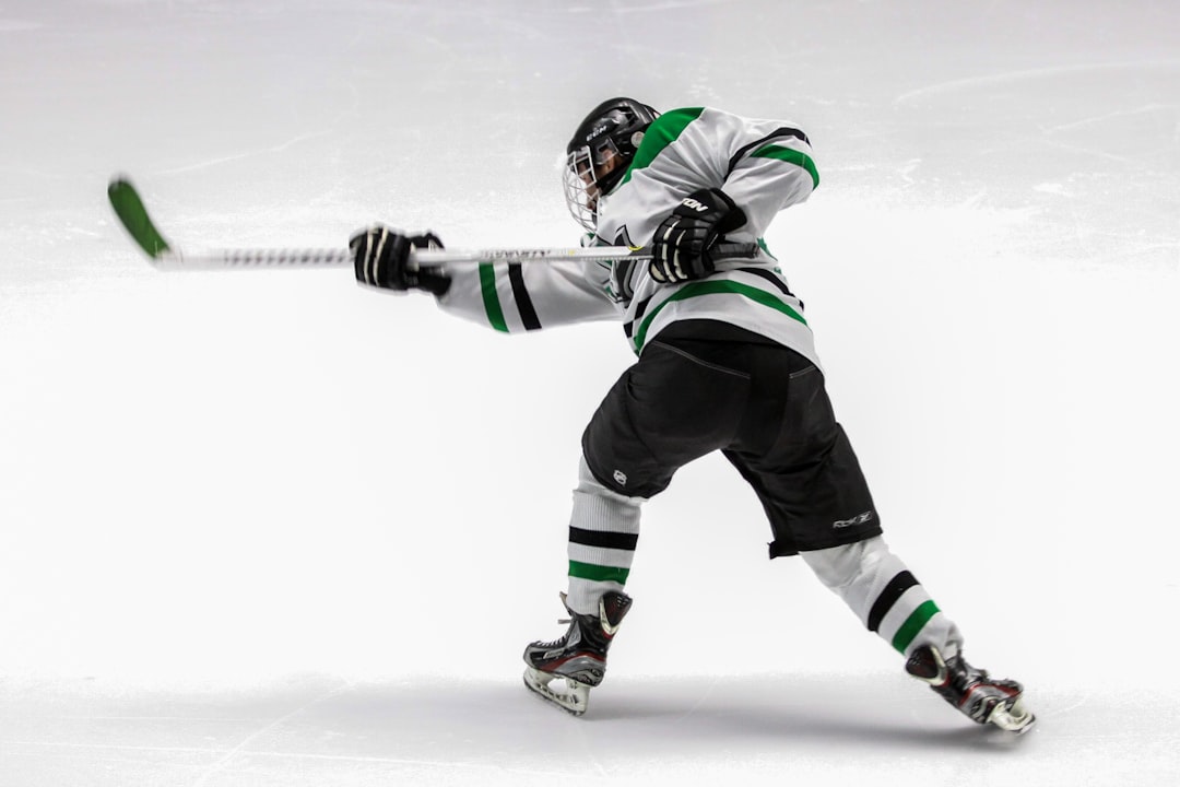 man wearing green and white ice hockey jersey while playing,