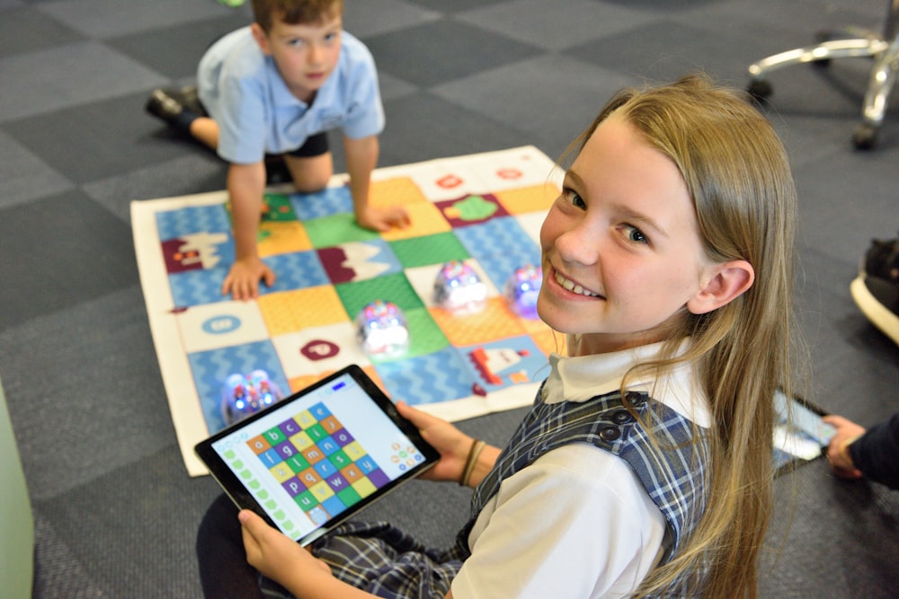 girl holding black tablet computer