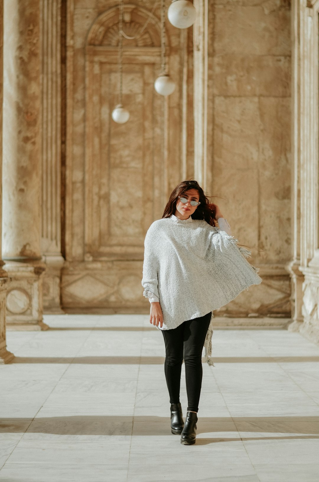 woman wearing white blouse walking on gray concrete surface