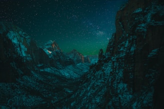 Nighttime panorama of the Chaco Canyon ruins illuminated subtly under a starry sky.