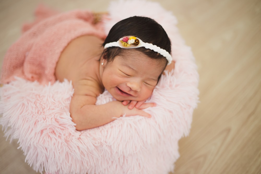 baby laying on pink bed