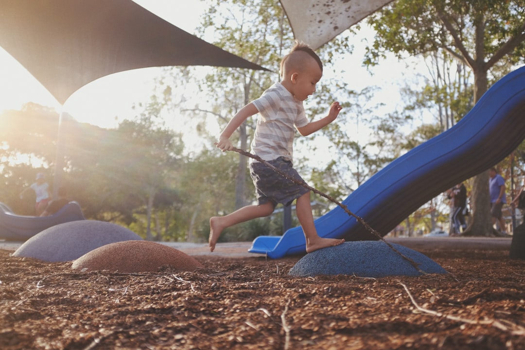 boy stepping on rocks in playground during daytime