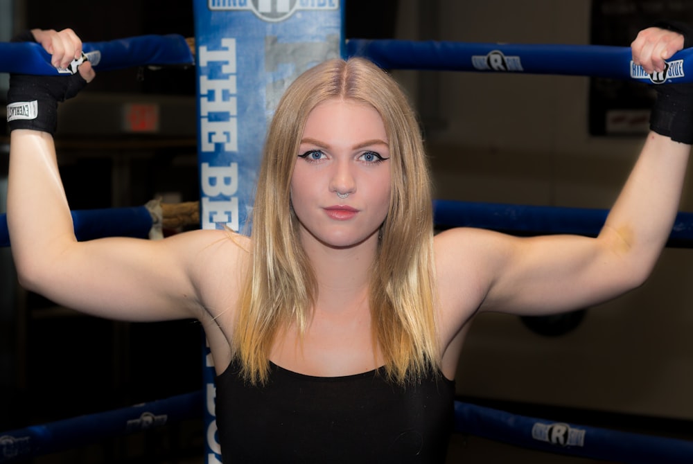 woman gripping boxing rink with both hand