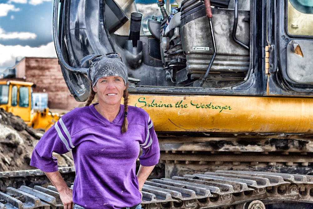 woman standing next to construction vehicle