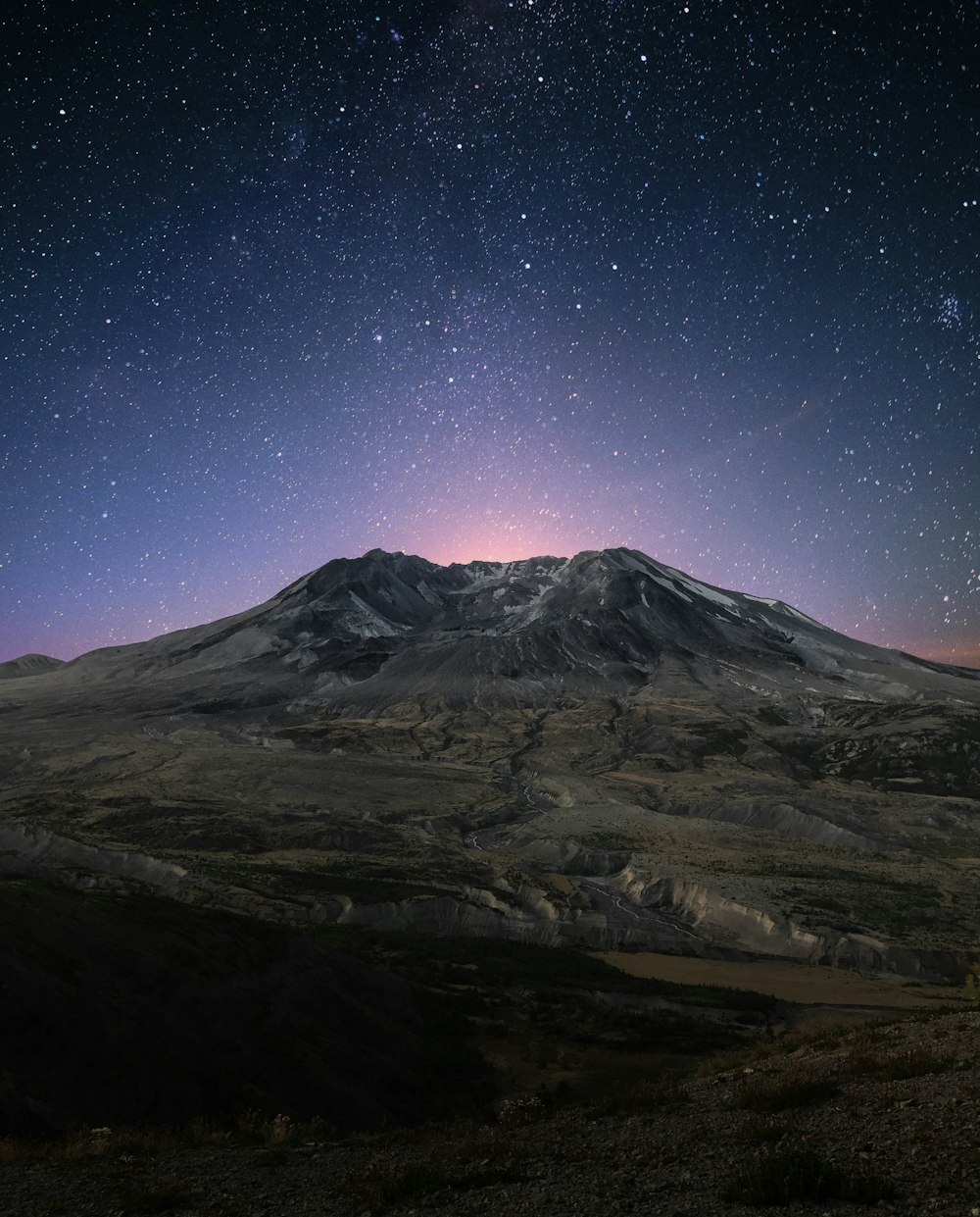 montanha coberta de neve durante a noite com estrelas