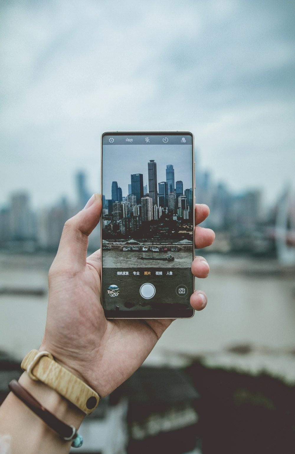 person with cityscape view on smartphone