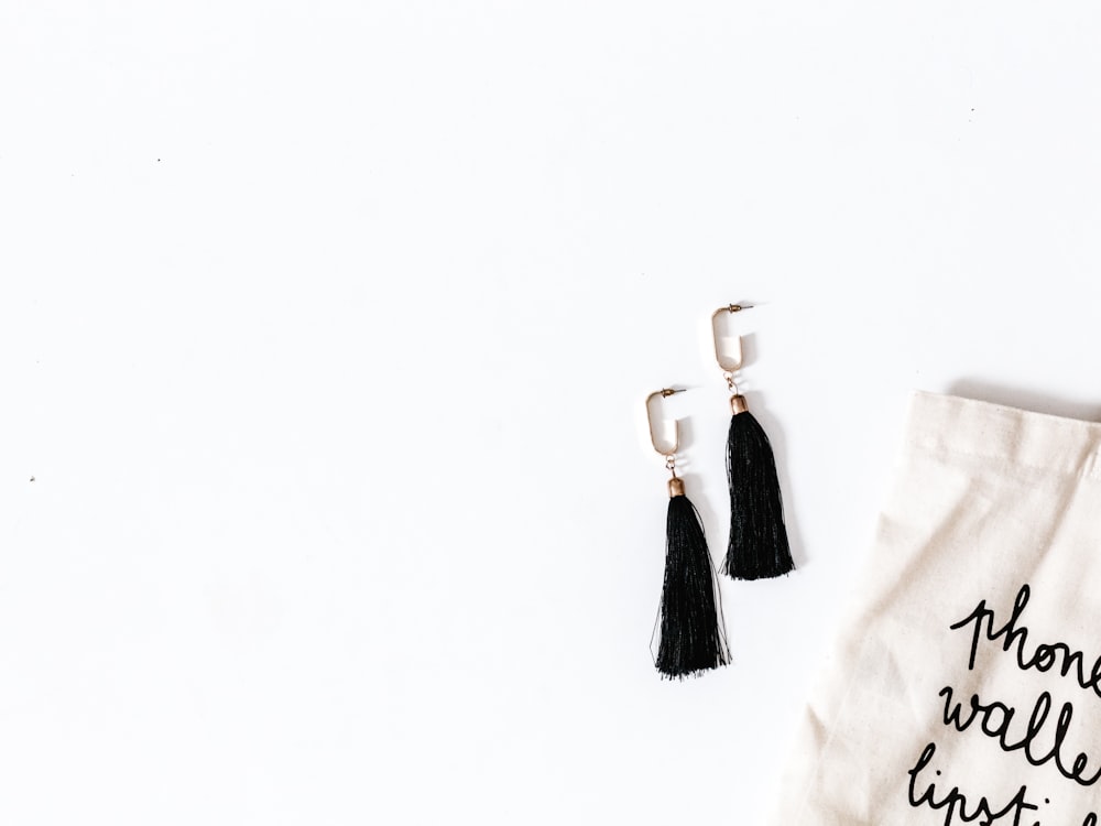 pair of black danging earrings on white surface