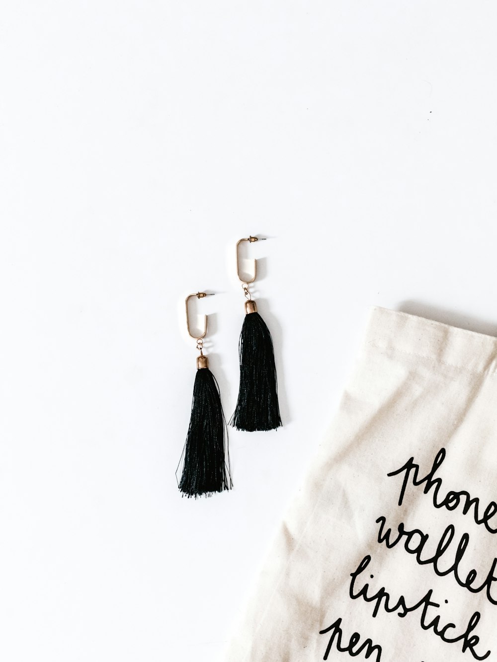silver-colored earrings and black tassels