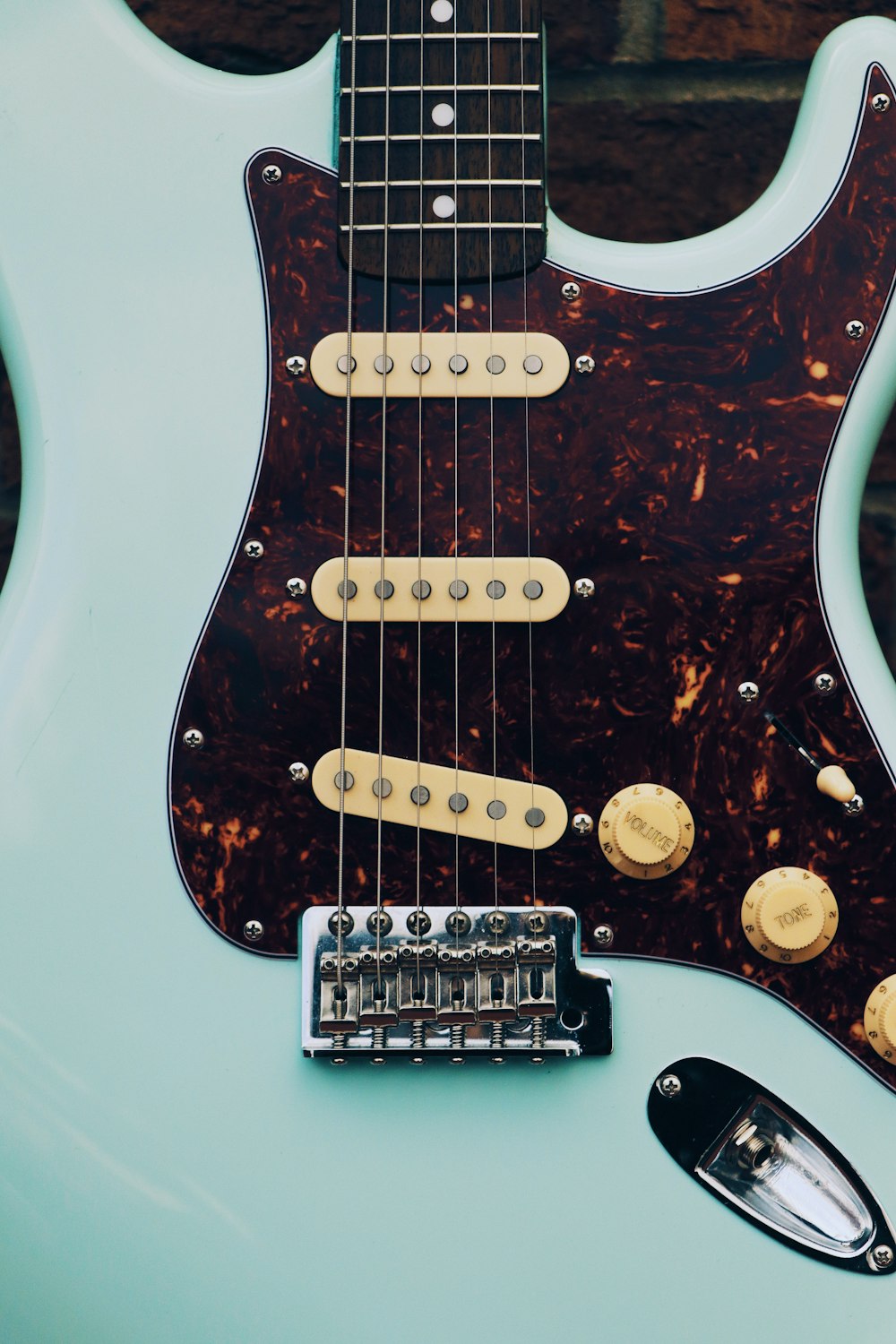 white and brown electric guitar