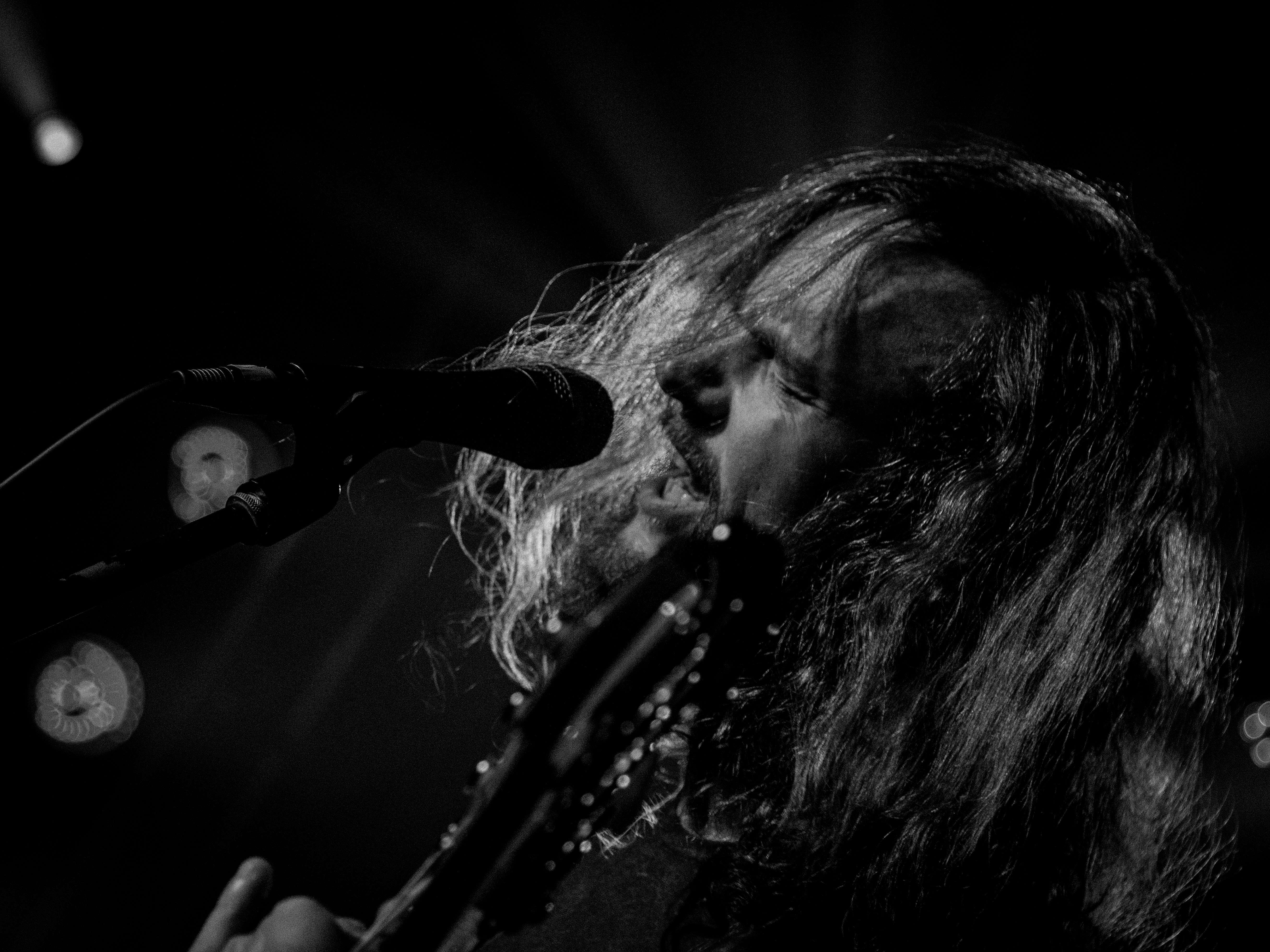 man singing in front of two microphones