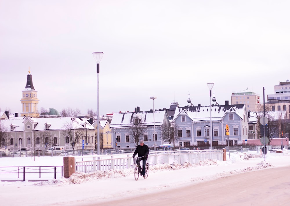 man riding bicycle near white concrete houses