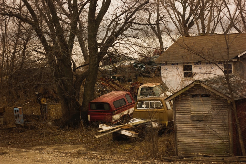 abandoned vehicles in front of house under the trees
