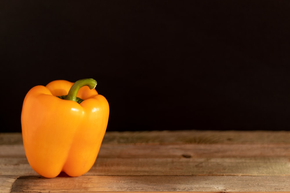 yellow bell pepper on brown wooden surface