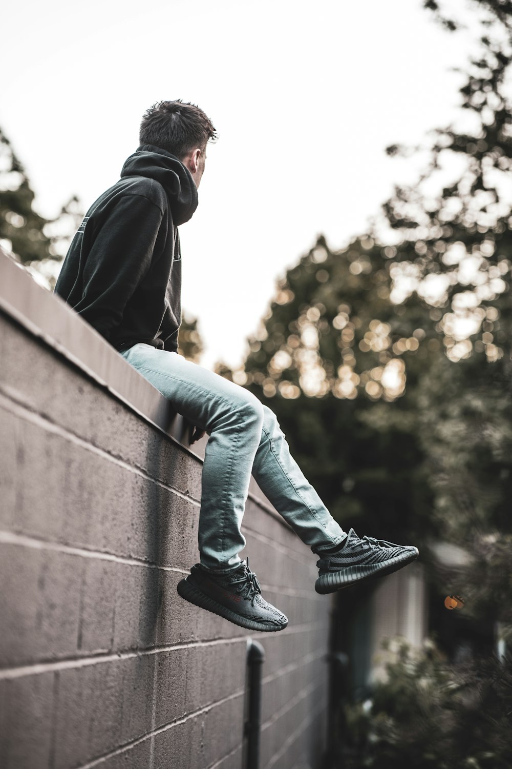 man sitting top of wall during daytime