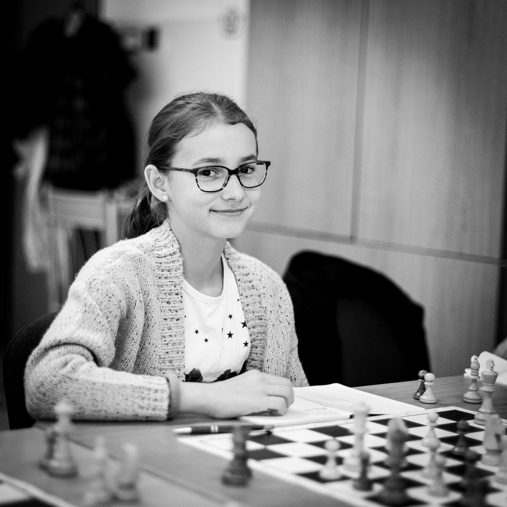 grayscale photo of girl playing chess