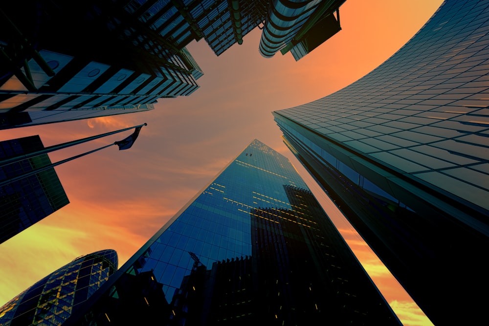 Fotografía de ángulo bajo de edificios de espejos durante la puesta de sol
