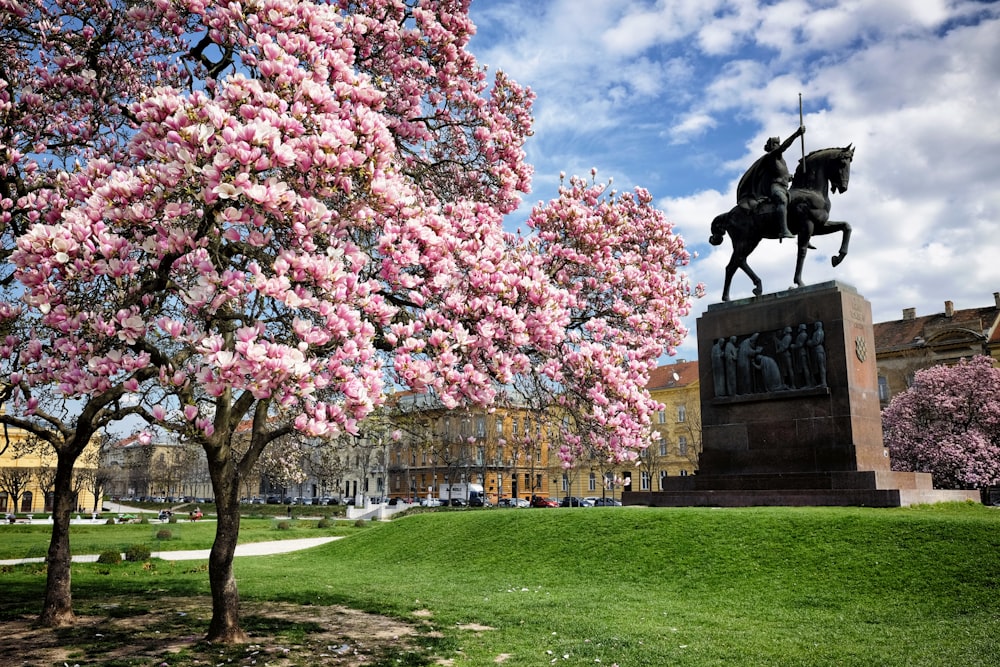 man riding horse statue near tree